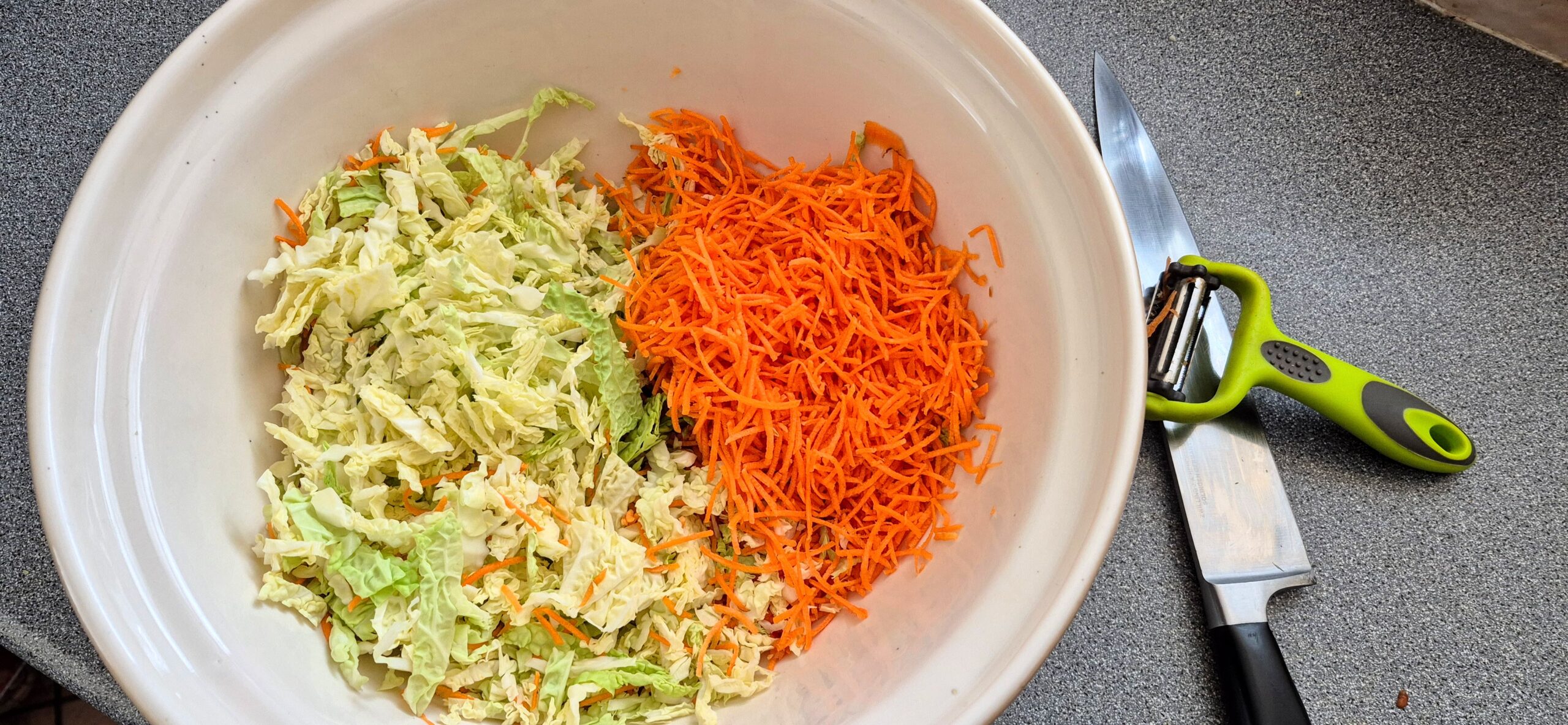 Shredded carrots added to the bowl